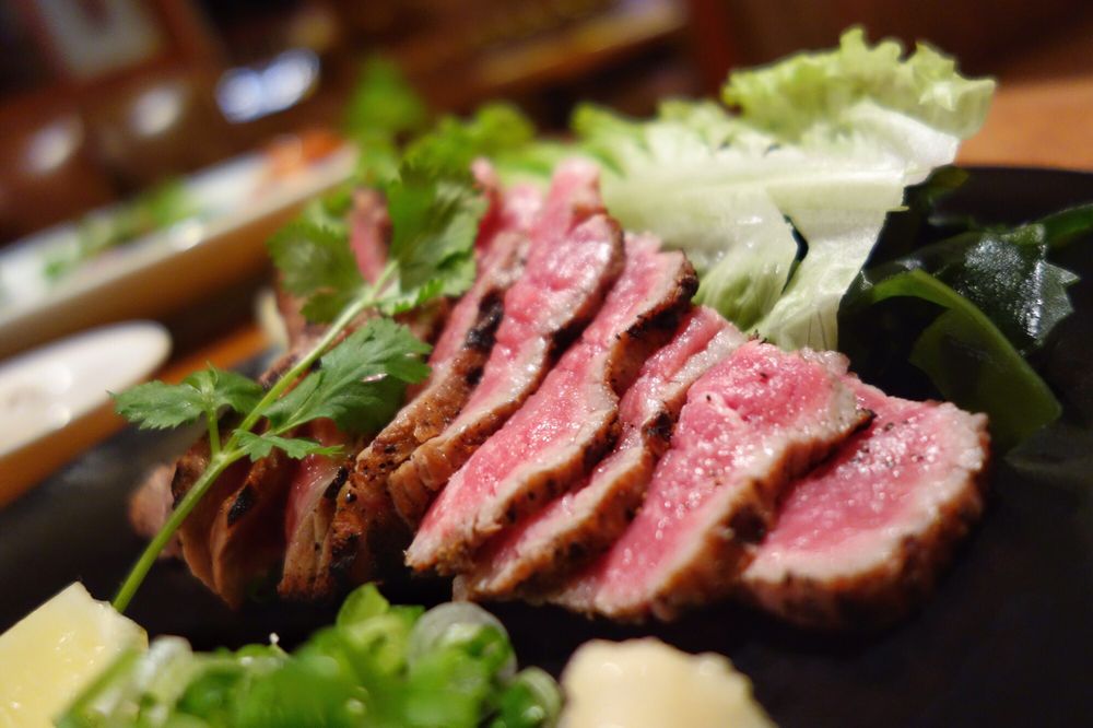 Slices of seared beef with fresh greens